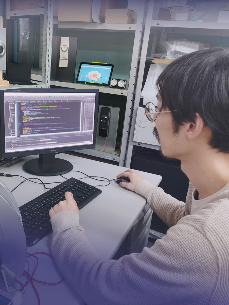 パソコンに向かって技術を開発している社員のイメージ画像(スマートフォン用)